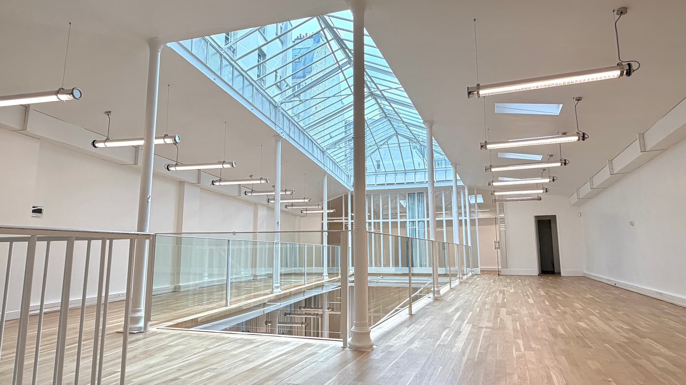 Mezzanine en parquet chêne traversée par la verrière en diagonale — Loft République