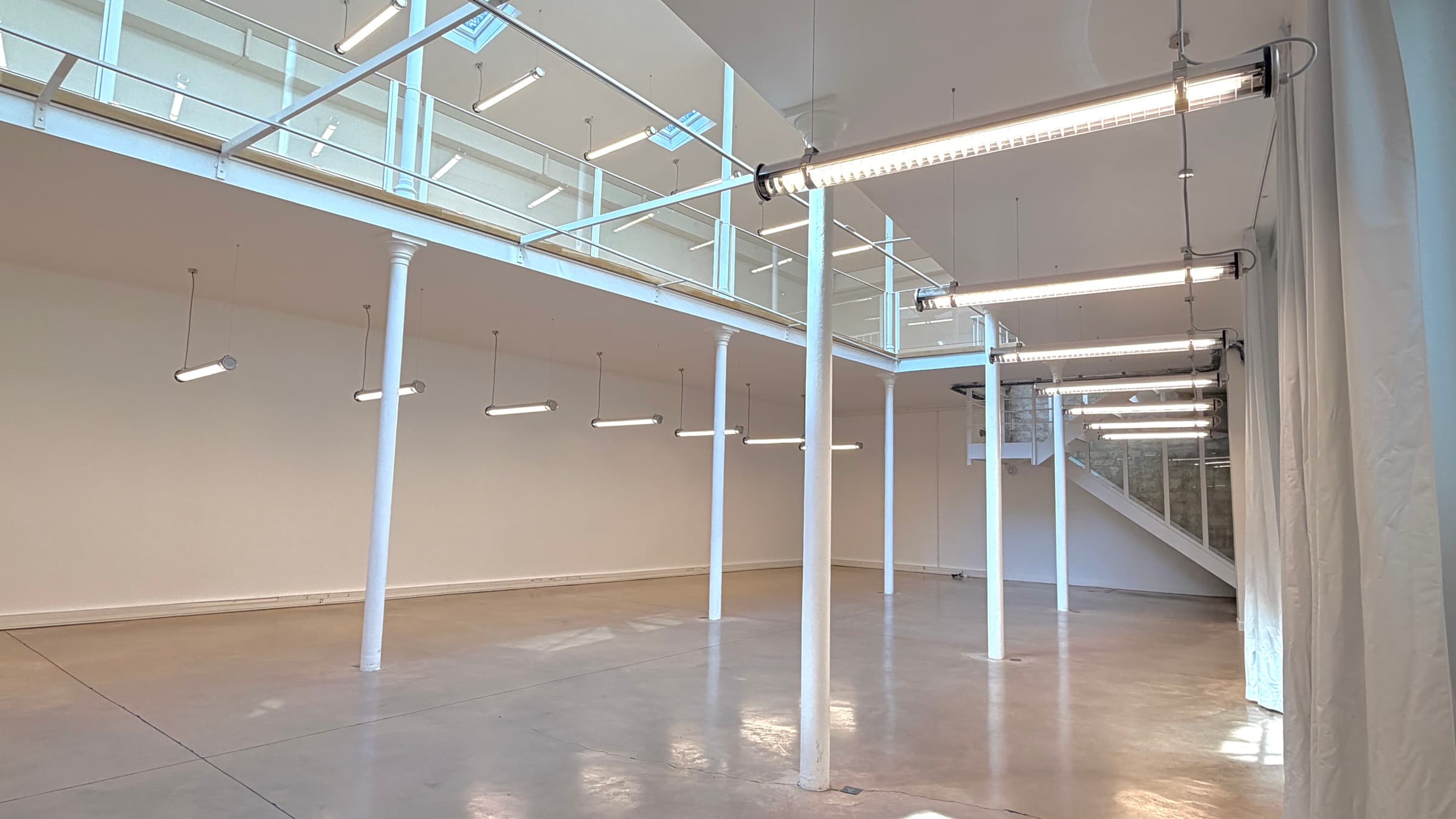 Plateau du RDC sous la mezzanine, double hauteur et colonnes — Loft République Paris
